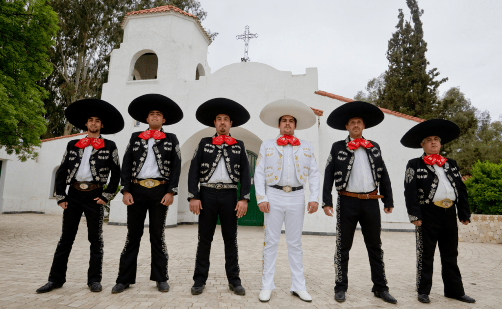traje de charro típico con 6 mariachis con traje negro y uno con traje blanco