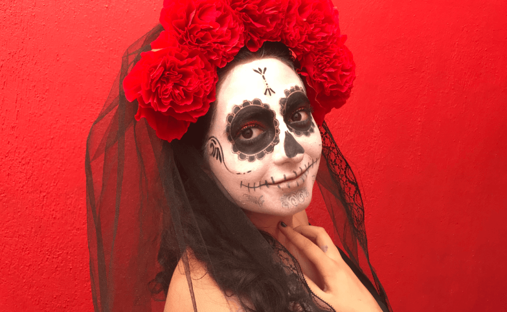mujer con maquillaje de día de muertos con velo de novia negro