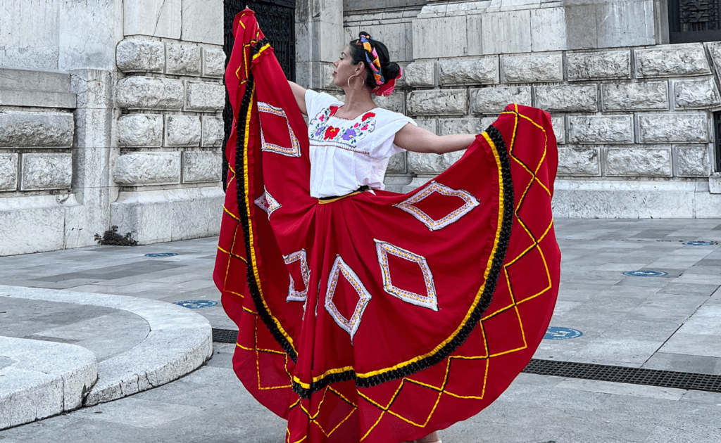 vestido tipico de zacatecas, color rojo con blusa de flores y achongo mexicano, en el fondo la catedral