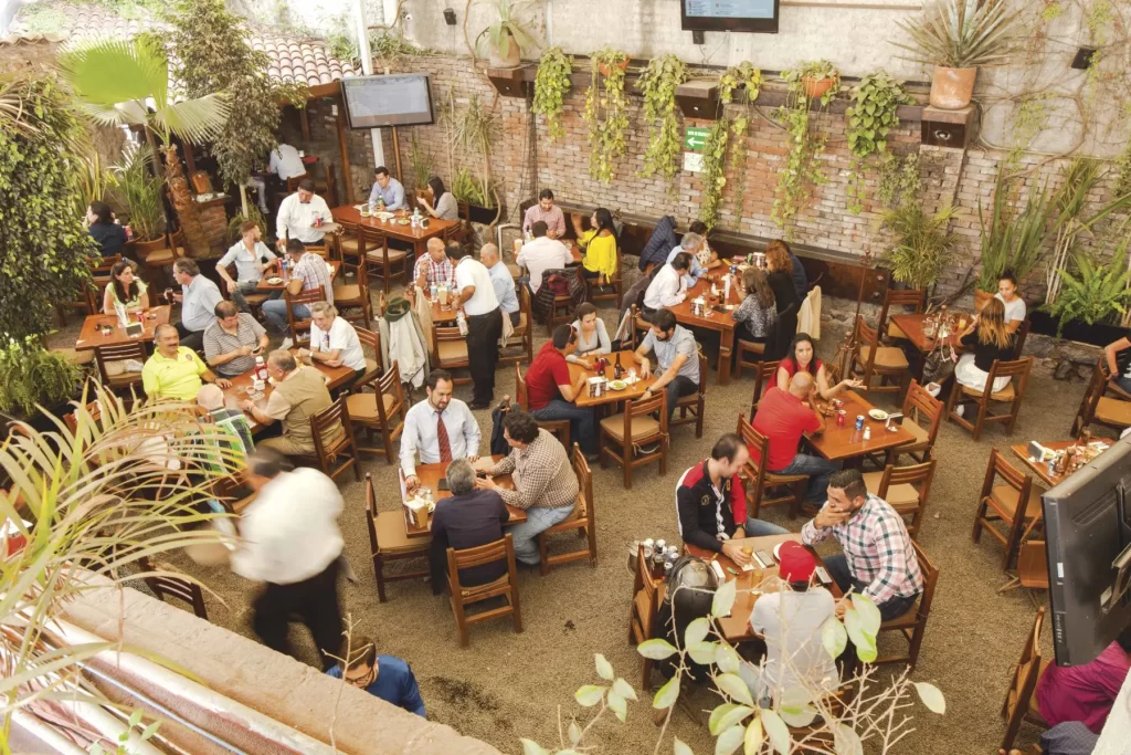 terraza de la coyoacana con flores decorativas y mesas para comer