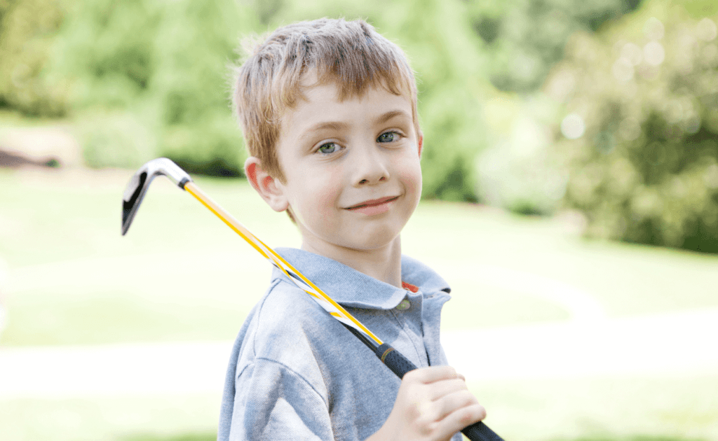 niño con un palo de golf